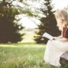 woman sitting while reading book