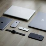 a group of cell phones and laptops on a table