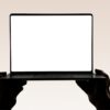 Hands hold up an open laptop with a blank screen.