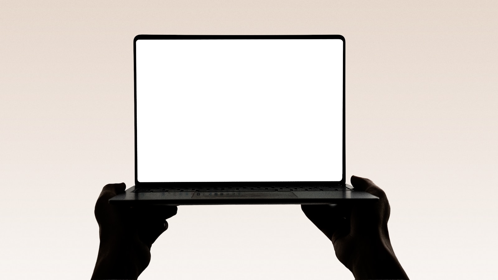 Hands hold up an open laptop with a blank screen.